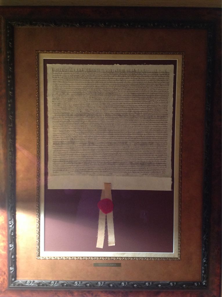 Three men in cloth caps, with Durham Castle and cathedral in the background, Durham, England. 1974.