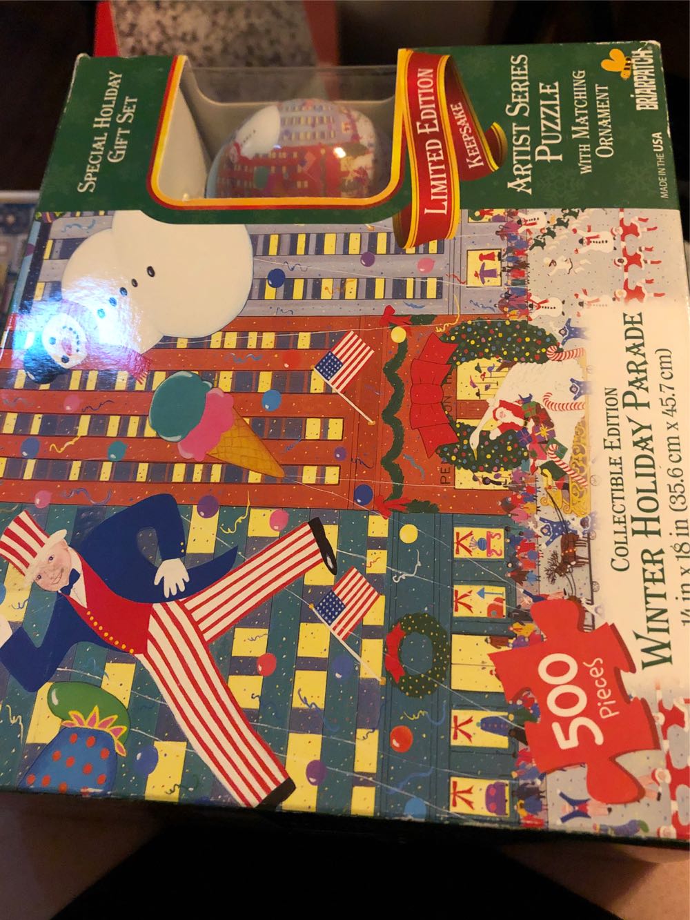 Winter Holiday Parade 500 Piece Limited Edition Keepsake Artist Series Puzzle With Matching Christmas Ornament Gift Set - Briarpatch puzzle collectible [Barcode 761707282143] - Main Image 2