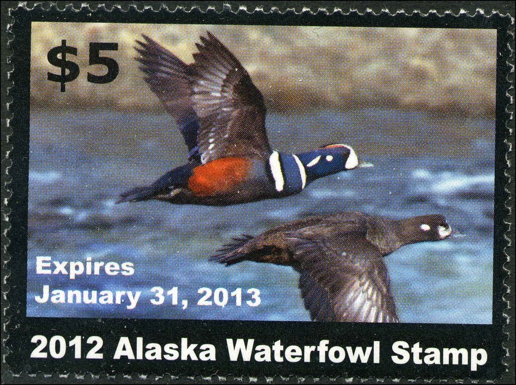 Fists holding rifle, spade, axe, sickle and book